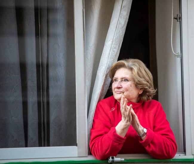 Una mujer, aplaude desde su ventana a las ocho de la tarde.