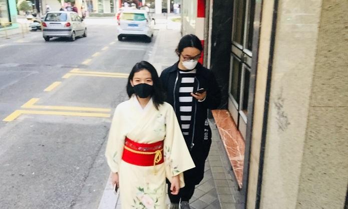 Dos japoneses pasean por una calle de Granada protegidos con mascarillas.
