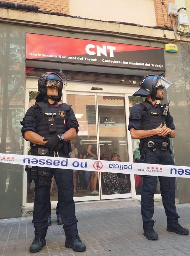 La foto corresponde a la protección  policial del local de la CNT en Barcelona ante las amenazas de los transactivistas porque se presentaba un informe sobre el Servicio Transit para el tratamiento de menores con disforia de género en Cataluña.