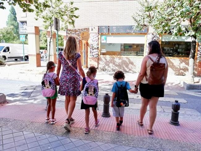 res escolares, con sus madres, se dirigen a su centro escolar en la capital.