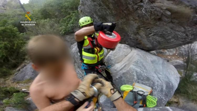 Los agentes preparan a uno de los menores para ser izado al helicóptero. 