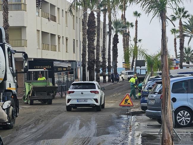 Operarios municipales limpian el barro de la calle Guadix. 