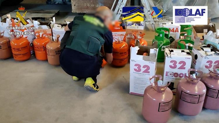 Un agente con parte de las botellas de gas intervenidas.