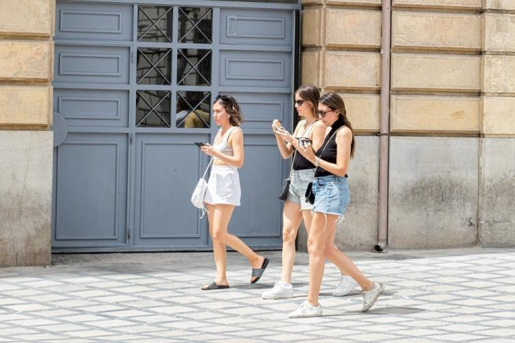 Varias chicas toman tarrinas de helado para refrescarse en la Granada capital. 