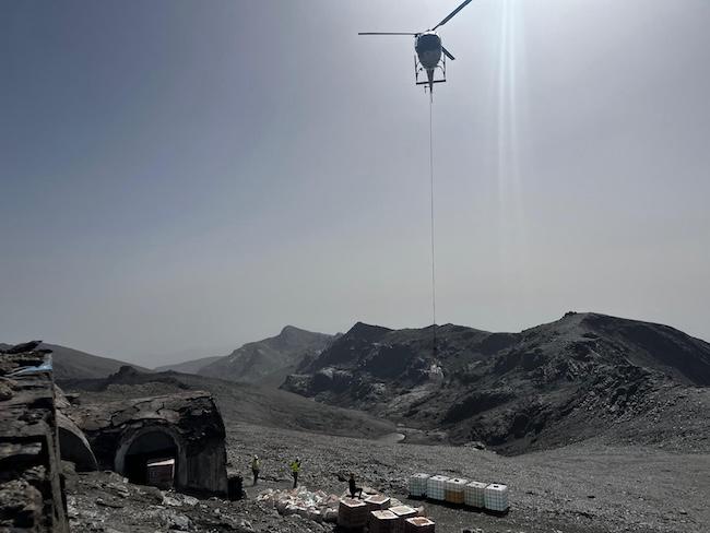 Un helicóptero deja material junto al refugio.