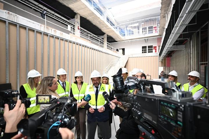 Responsables políticos atienden a los medios dentro del edificio en obras.