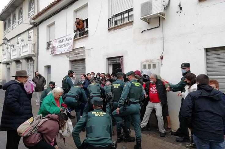 Los agentes intentan retirar a las personas apostadas en la puerta de la vivienda. 