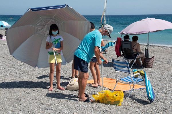 Bañistas en Playa Granada cumpliendo con el uso de mascarilla.