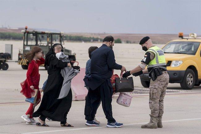 Varios refugiados tras la llegada de un nuevo avión con 260 personas procedentes de Afganistán, en la base aérea de Torrejón de Ardoz, a 23 de agosto de 2021, en Madrid. 