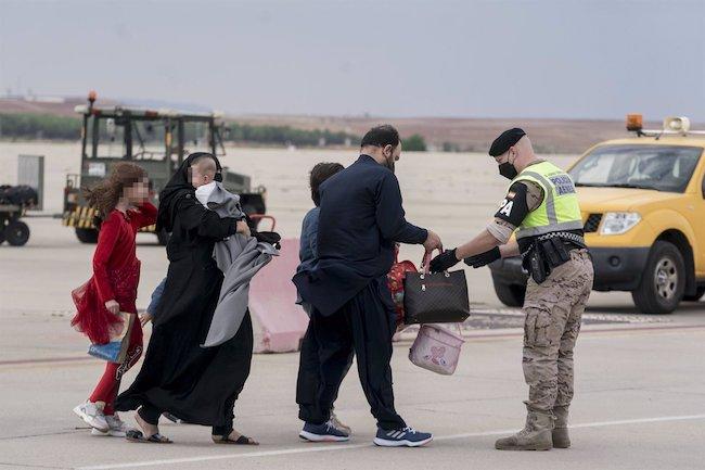 Varios refugiados tras la llegada de un nuevo avión con 260 personas procedentes de Afganistán, en la base aérea de Torrejón de Ardoz, a 23 de agosto de 2021, en Madrid.