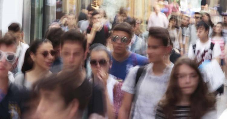 Jóvenes pasean por la calle mesones.