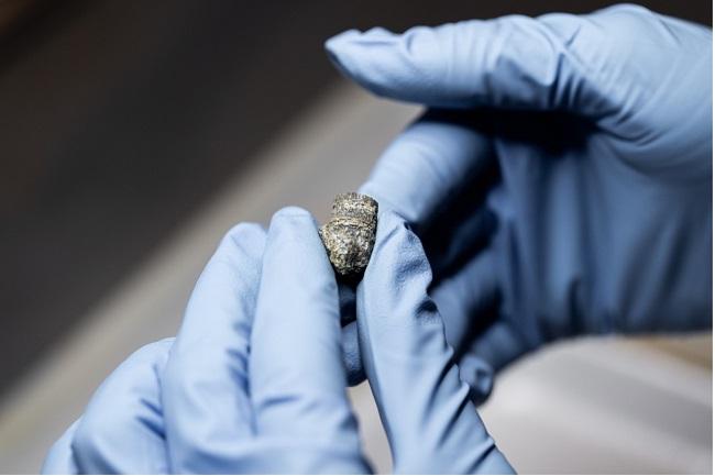 Uno de los integrantes del equipo sostiene una bala localizada junto a los cuerpos.