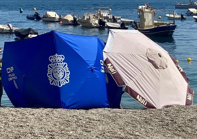 Lona dispuesta por la Policía en la playa de Calahonda tras rescatar el cadáver.