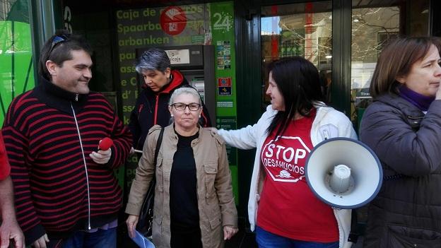 Conchi, en el centro, sale de la sucursal tras lograr el acuerdo. 