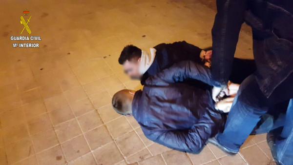 Dos de los detenidos, esposados en el suelo.