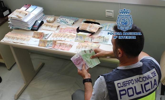 Un agente cuenta el dinero intervenido a la red delictiva, 20.000 euros.