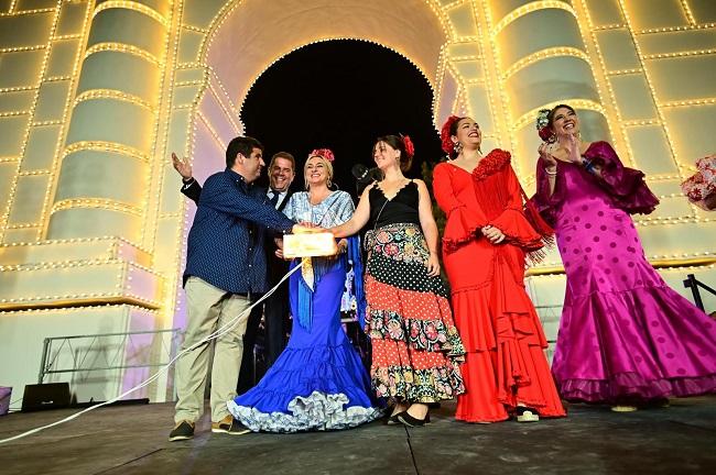 En la fotografía, junto a la alcaldesa y el pregonero del Corpus, Ana María Jiménez Boland, la vecina encargada del alumbrado y Estefan Rosillo, entre otros. Encendido del ferial de Granada.