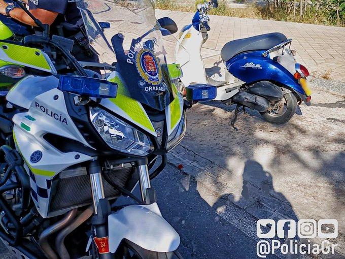 Una moto policial, junto al ciclomotor del detenido. 