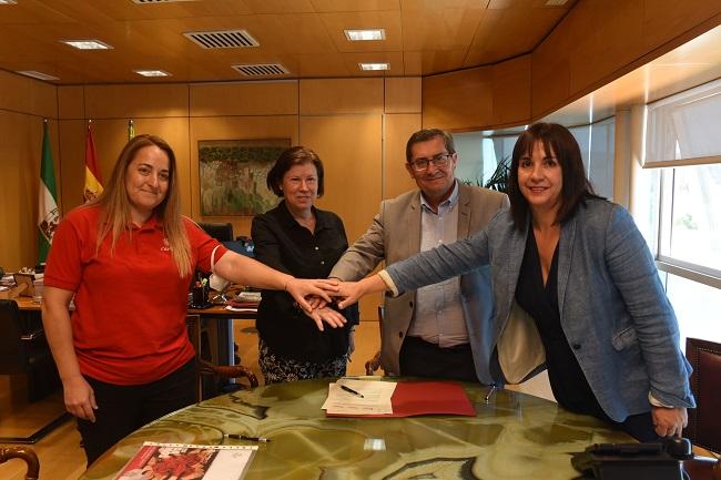 Firma del convenio con las responsables de Cáritas. 