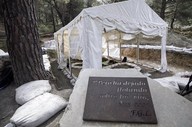 arpa que cubre los trabajos para las exhumaciones en el barranco de Víznar (Granada) junto a una placa con un poema de Federico García Lorca. Archivo. 