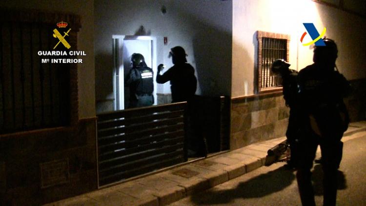 Agentes entran en un domicilio durante la operación policial. 