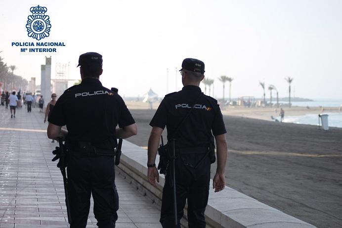 Agentes policiales patrullan por una playa. 