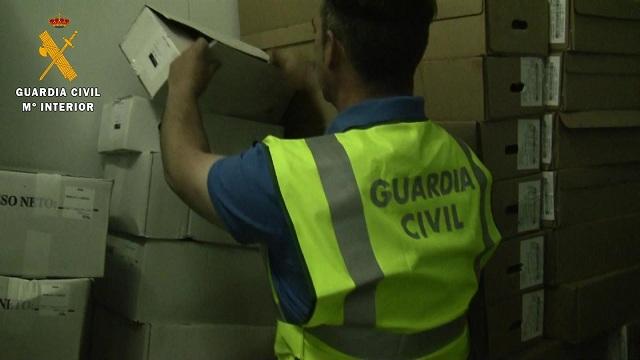 Un agente inspecciona productos del detenido. 