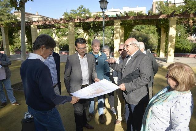 El alcalde examina los planos de la obra en la plaza. 