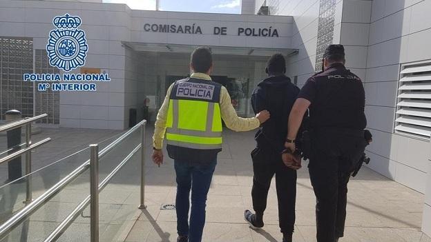 Agentes conducen a uno de los detenidos. 