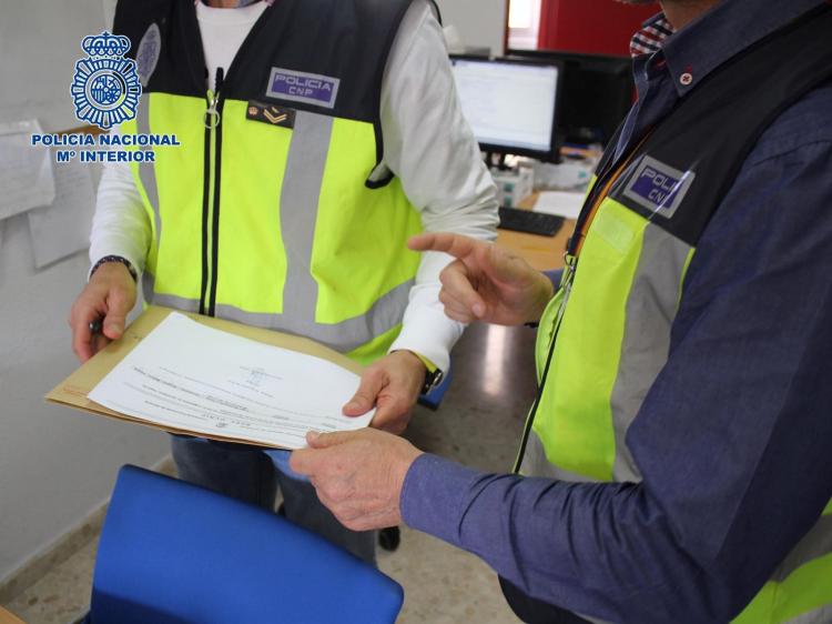 Agentes examinan documentación Agentes examinan documentación.