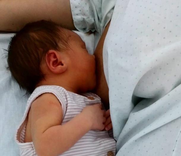 Bebé lactante nacido recientemente en el hospital, junto a su madre.