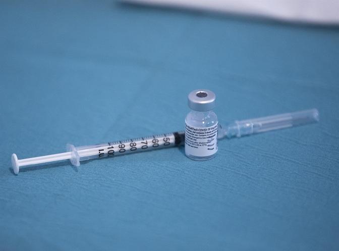 Una jeringa junto a un vial de la vacuna de Pfizer.