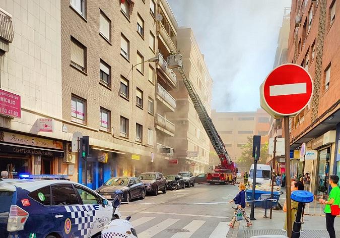 Bomberos actúan contra el fuego con la calle cortada al tráfico. 