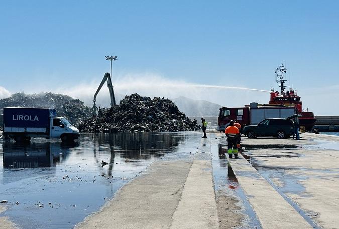 Bomberos rematan la extinción del fuego sobre el montón de chatarra. 