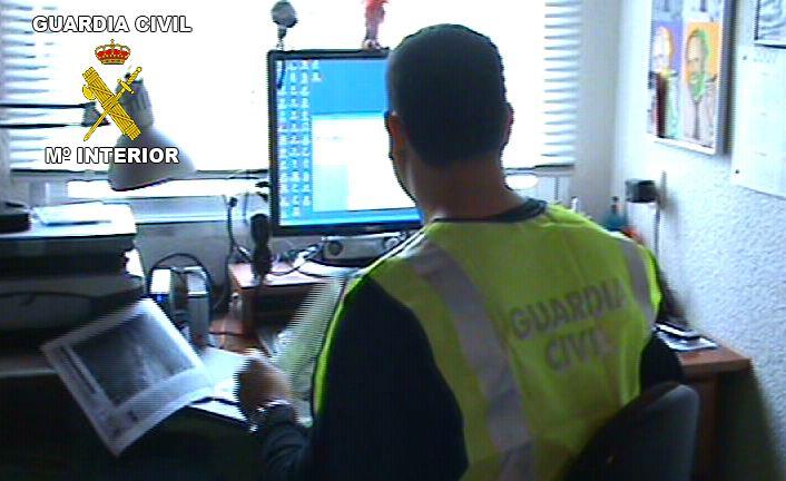 Un agente investiga en su ordenador Un agente investiga en su ordenador.