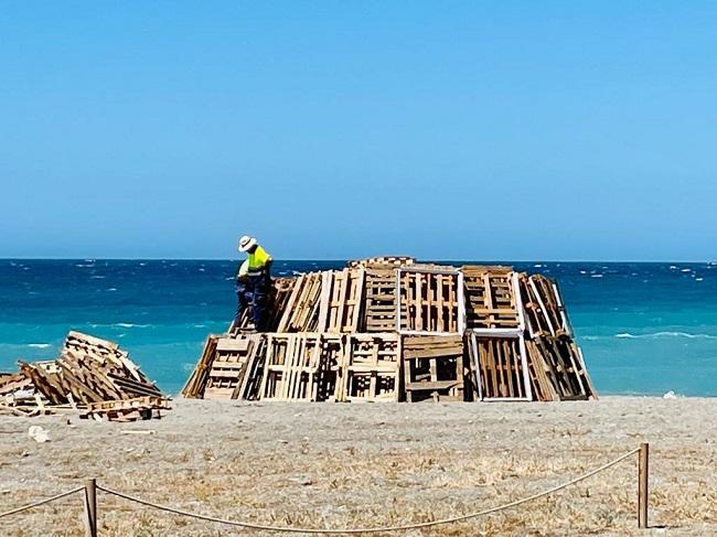 Operarios municipales preparan una gran hoguera en la playa de Salobreña.