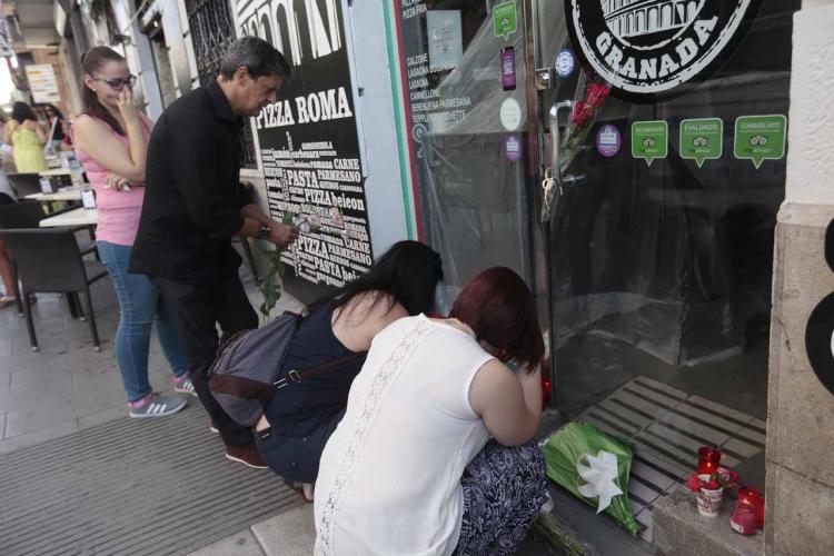 Familiares y allegados han depositado flores y velas a las puertas de la pizzería que regentaba Ana.