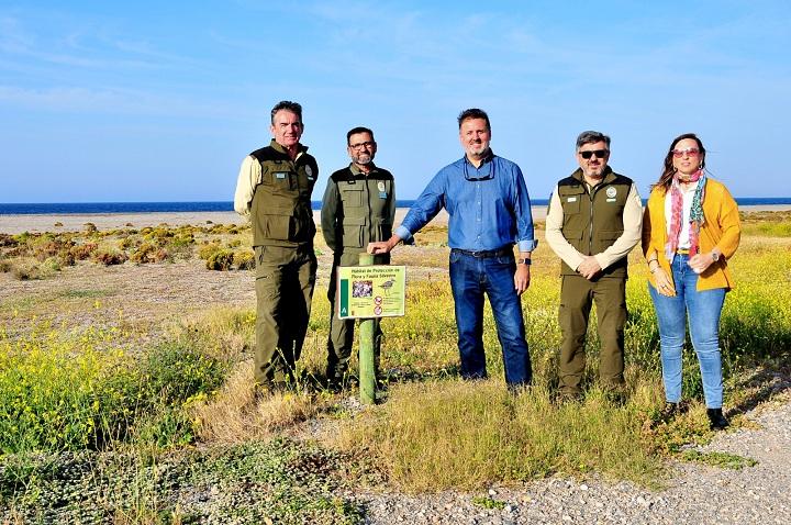 Autoridades y agentes de Medio Ambiente, junto a uno de los carteles informativos colocados en la playa de Carchuna