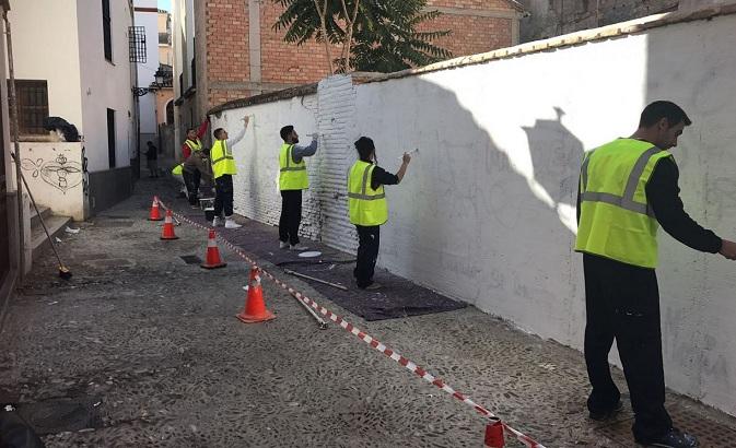 La cuadrilla limpia una pared en el Albaicín.