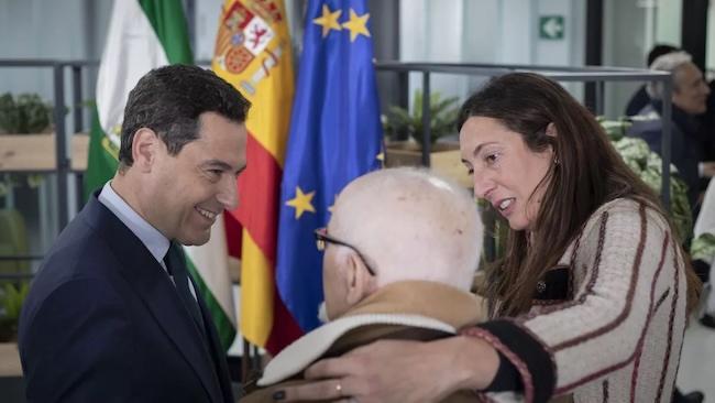 Juan Manuel Moreno, presidente de la Junta, y Loles López, consejera de Inclusión Social, saludan a un mayor en una imagen de archivo. EP/Archivo.