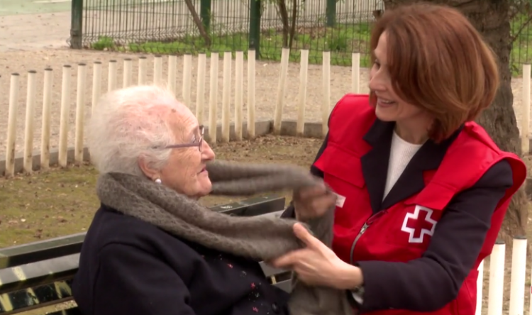 Una voluntaria de Cruz Roja atiende a una mujer mayor.