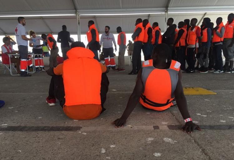 Migrantes rescatados aguardan a ser atendidos por voluntariado de Cruz Roja en el Puerto de Motril.
