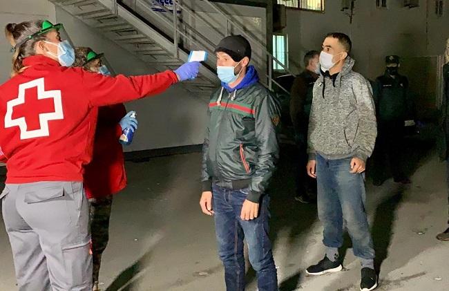 Una voluntaria de Cruz Roja toma la temperatura a los migrantes. Una voluntaria de Cruz Roja toma la temperatura a los migrantes.