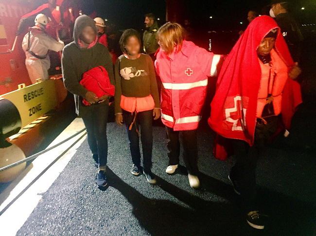 Una voluntaria de Cruz Roja atiende esta madrugada a las personas trasladadas al Puerto de Motril.