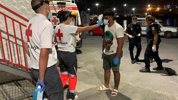 Voluntarios de Cruz Roja toman la temperatura a uno de los migrantes.