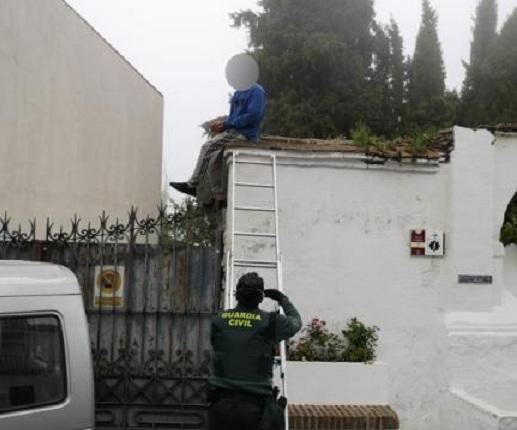 Un agente habla con el joven, subido a un muro. 