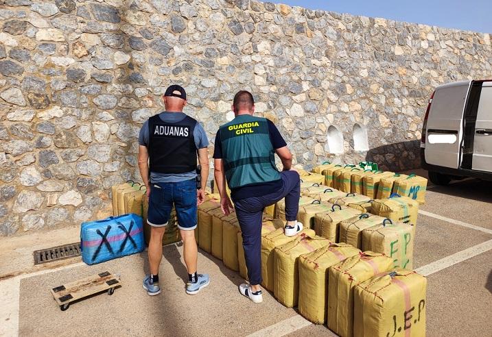 Agentes, con los fardos de hachís requisados. 