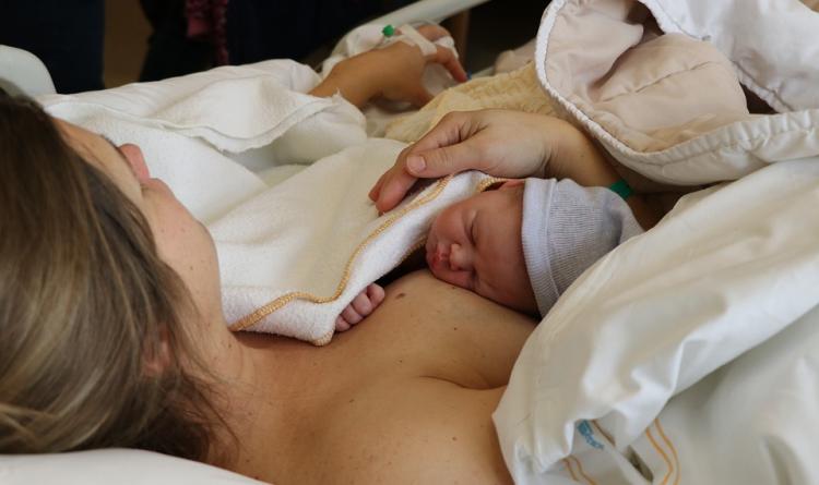 Una madre con su recién nacido tras el parto. 