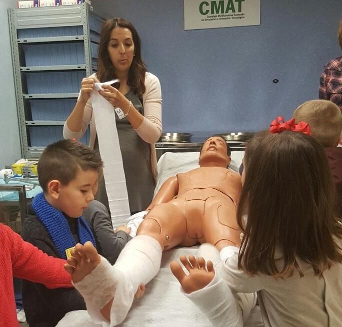 Escolares practican vendajes con un maniquí.