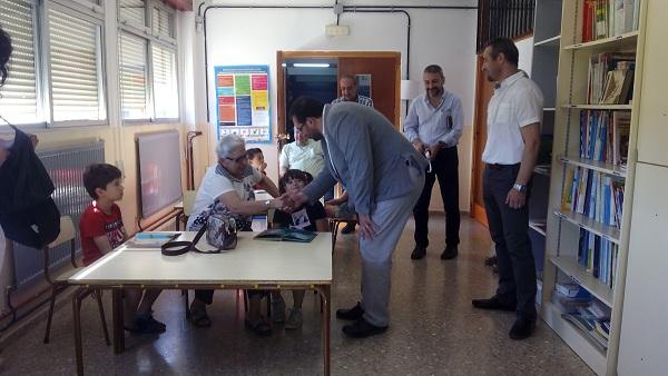 El delegado de Educación saluda a una de las personas mayores que interactúan con los escolares.